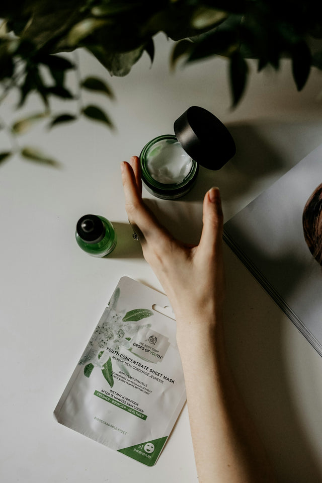 Main attrapant un pot de crème et un sérum