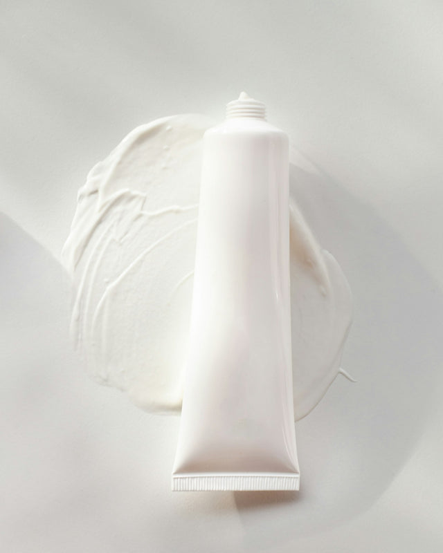 Tube de crème sur une assiette blanche
