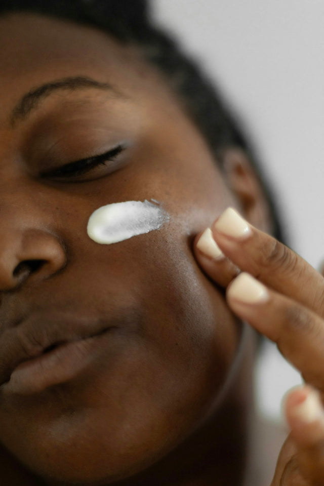 Femme appliquant une crème sur son visage