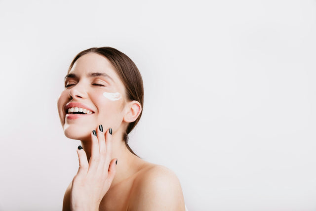 Femme souriante, la main posée sur son visage