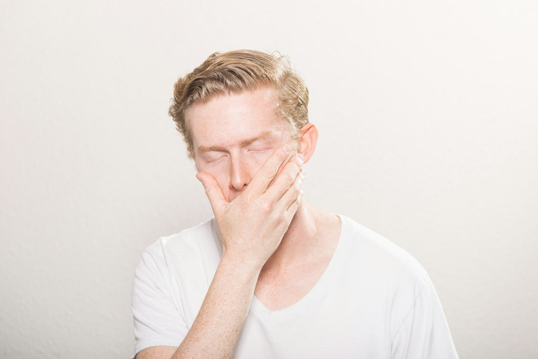 Homme se couvrant la bouche pour éternuer