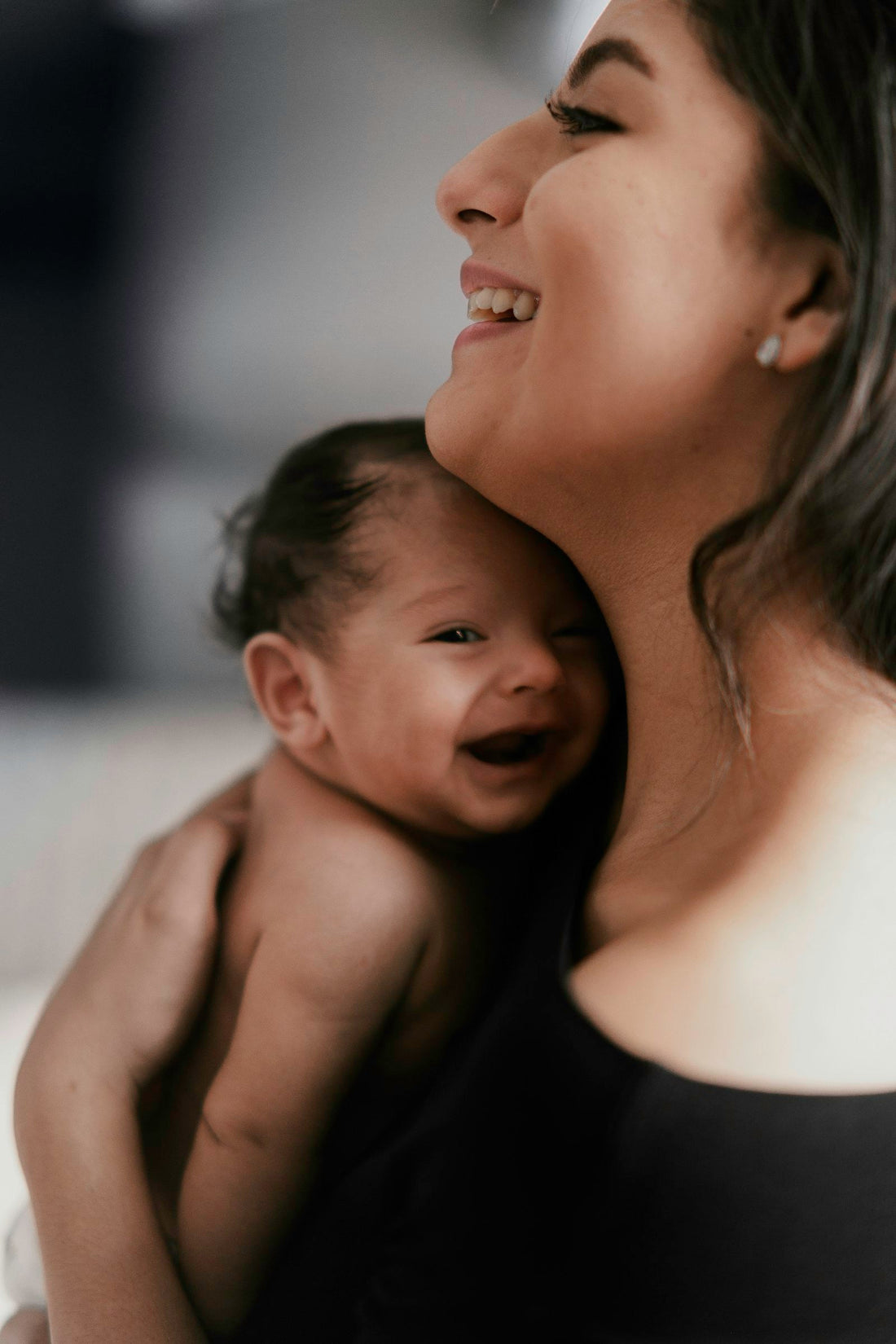 Mère portant son bébé souriant