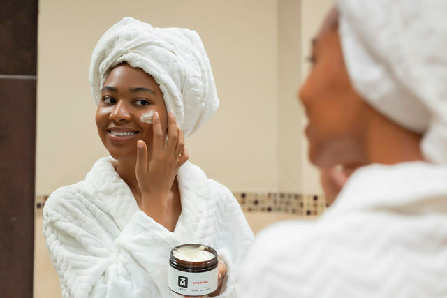 Femme avec une serviette et un pot de crème