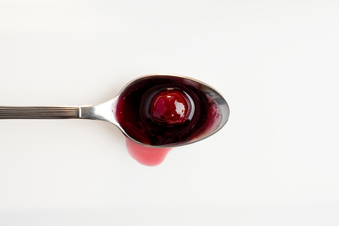Cuillère remplie de sirop rouge