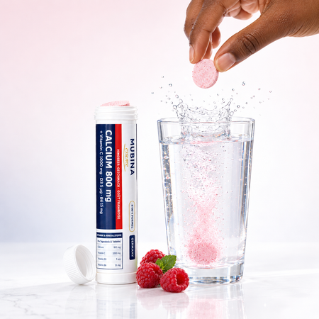 Comprimé effervescent Mubina Calcium 800 mg plongé dans un verre d'eau, goût framboise