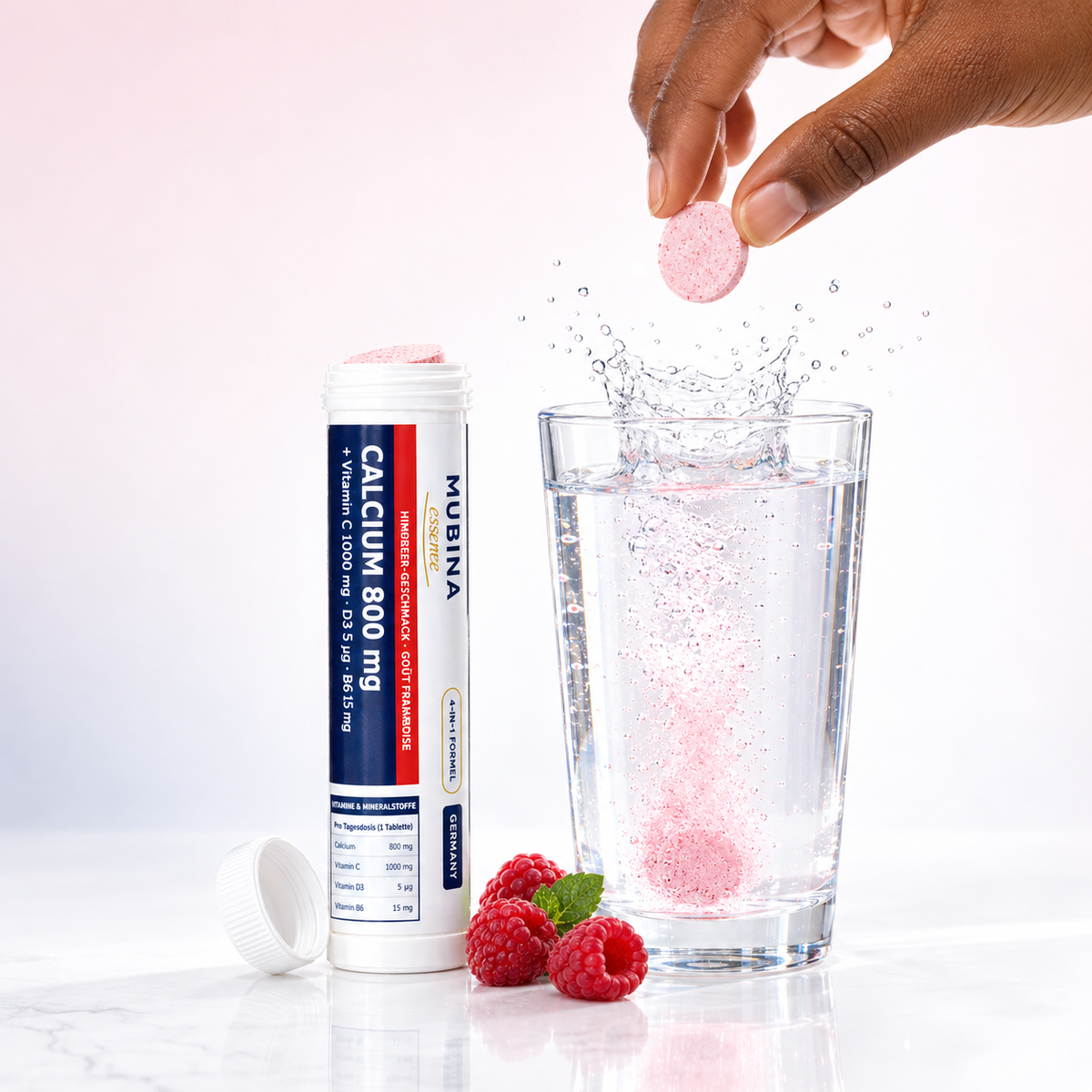 Comprimé effervescent Mubina Calcium 800 mg plongé dans un verre d'eau, goût framboise